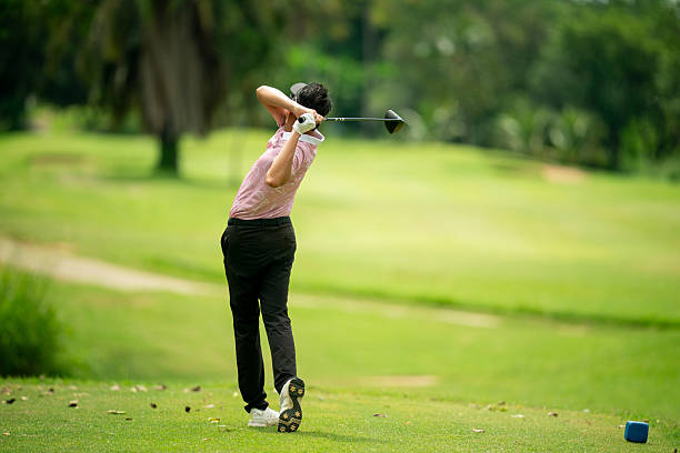 istock A man is swinging a golf club on a green course 2220750207