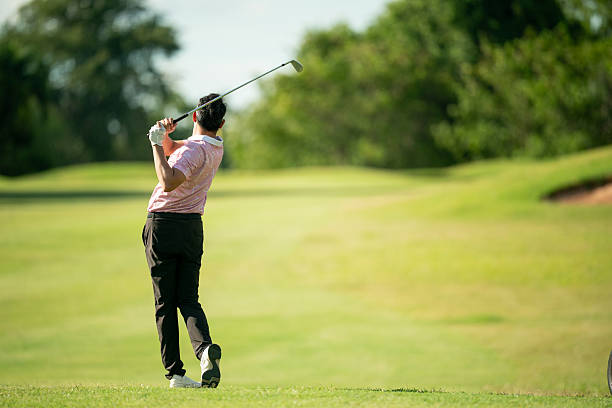 istock A man is swinging a golf club on a green course 2220750271