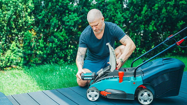 istock Man installing battery in electric lawn mower in garden 2220752810