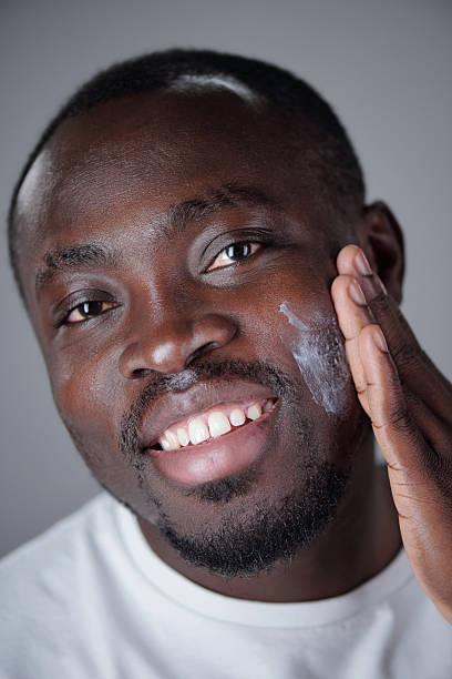 istock Portrait of Smiling Man Applying Face Cream 2220757227