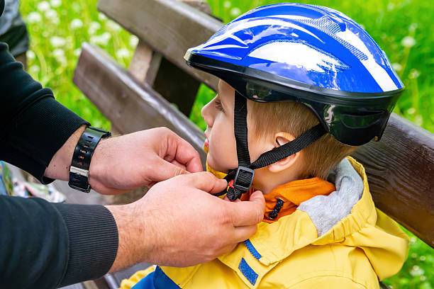 Father puts fall protection on his son for roller skating,wears helmet.Sport,communication between parents children,parenting child care,family time together