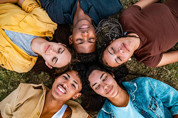 istock Young friends lying on grass outdoors 2220761828