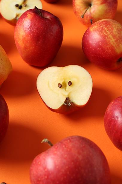 istock Many fresh red apples on orange background 2220763033