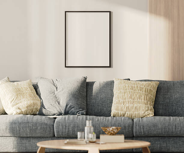 istock blank frame mock-up on a white wall with wooden panel above blue sofa in living room, 3d render 2220764320