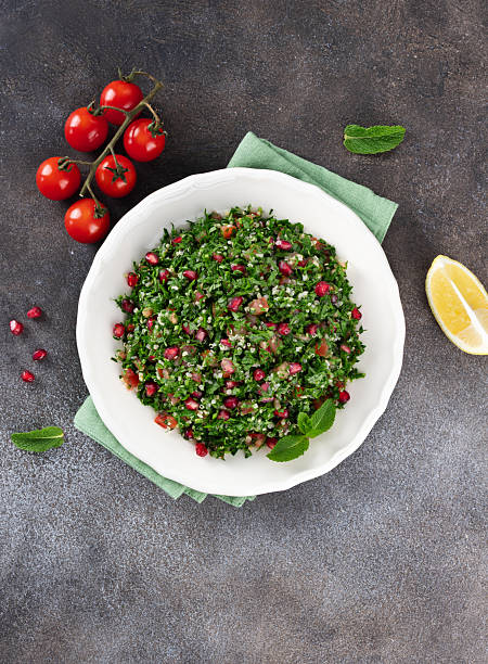 Levantine vegetarian salad with quinoa, tomatoes, pomegranate, parsley, lemon and dressing. Macro. Tabbouleh salad.