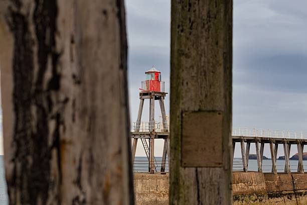 istock A tall red marker stands on the horizon between two wooden posts. 2220778951