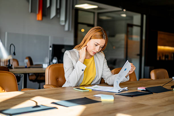 Businesswoman reviewing documents at office desk