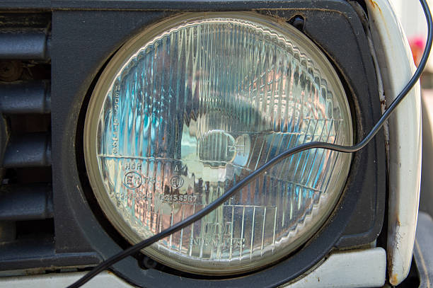 istock Close view of a classic vehicle headlight showcasing its reflective surface and intricate patterns illuminated by sunlight 2220785221