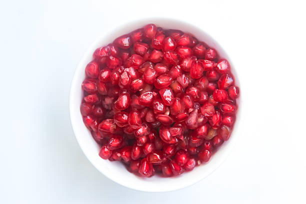 istock pomegranate seeds in a glass bowl isolated 2220785365