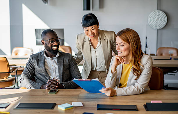 istock Smiling business team reviewing documents in modern office 2220785789