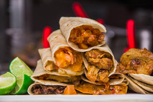 istock An enticing stack of layered tacos filled with fresh, colorful ingredients, served alongside lime wedges, exemplifying the essence of Mexican culinary artistry and flavor. 2220791610