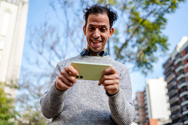 man playing with his smartphone on the street