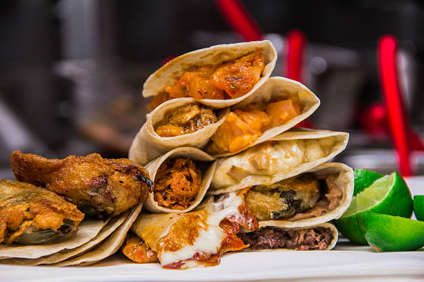 A visually striking arrangement of tacos accompanied by lime wedges, showcasing an array of enticing fillings, illustrating the creativity and diversity in Mexican gastronomy.