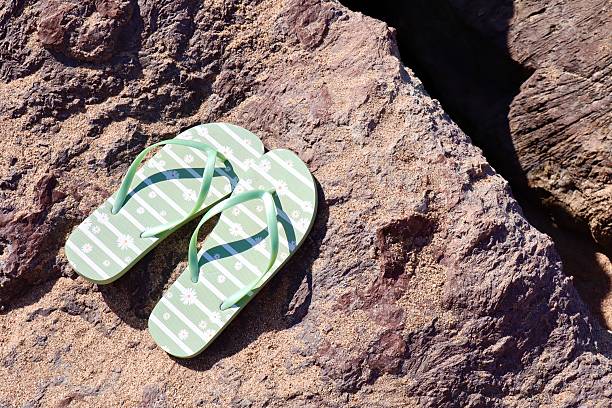 worn flip flops left on the grass