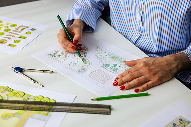 istock landscape architect, designer drawing ornamental garden plan in office 2220792982
