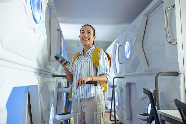 istock Woman exploring capsule hotel with smartphone and backpack 2220795021