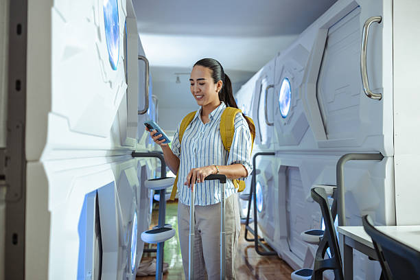 istock Woman exploring capsule hotel with smartphone and backpack 2220796233