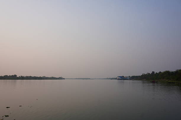 A tranquil body of water, possibly a river under a hazy or misty sky