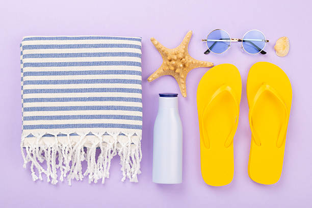 istock Beach towel with summer accessories on color background, top view 2220800508