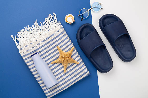 istock Beach towel with summer accessories on color background, top view 2220800510