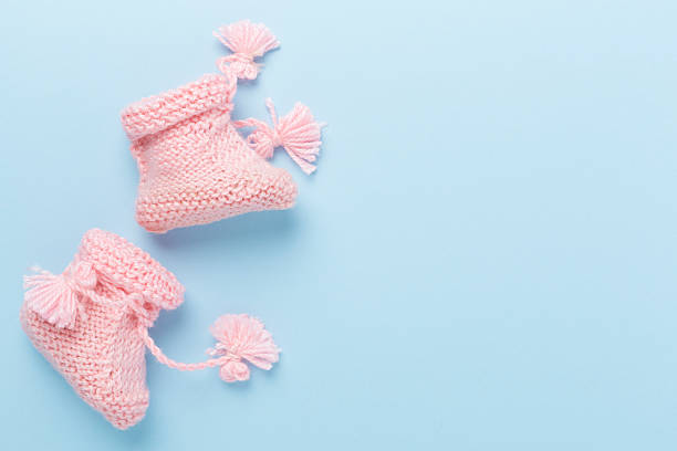 istock Pink baby booties on color background, top view 2220801733