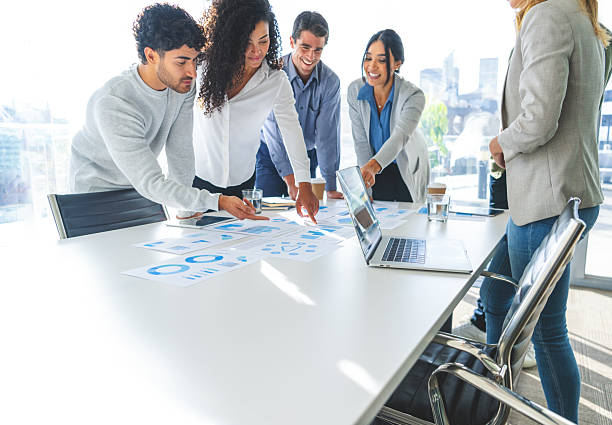 istock Financial and business documents on table with multiethnic group of people working on them. 2220803201