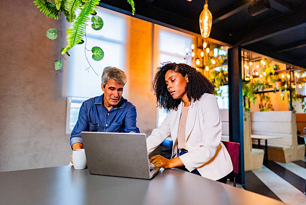 istock Coworkers talking and using laptop on the office 2220806483
