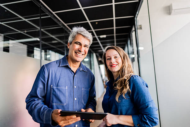 istock Portrait of coworkers using digital tablet in the office hallway 2220807364