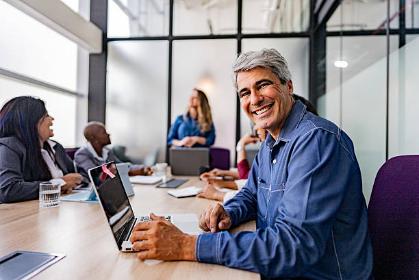 istock Mature businessman using laptop during meeting at office 2220807714