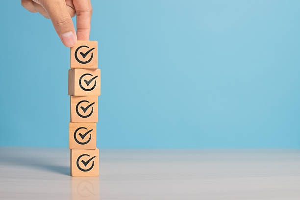 istock Check mark icon on wooden cube symbolizing goal achievement, verification, or progress tracking. Clean background with space for text. 2220811095