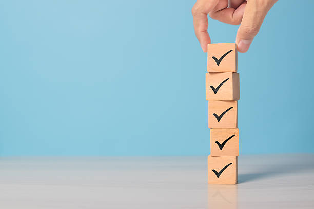 istock Wooden blocks with check mark icon on blue surface. Represents task completion, to-do list, or approval concept. 2220811101
