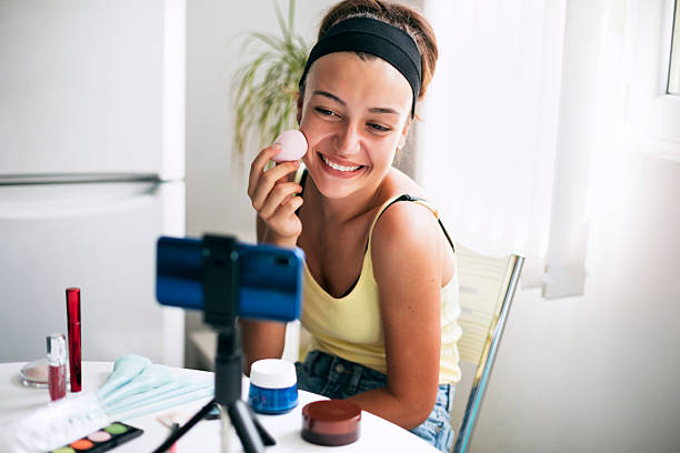 istock Cheerful teenage girl applying foundation using a makeup sponge 2220814164