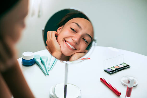 istock Beautiful girl smiling at her reflection in a mirror 2220814245