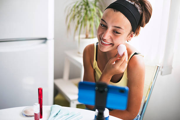 istock Cheerful teenage girl applying foundation using a makeup sponge 2220814278