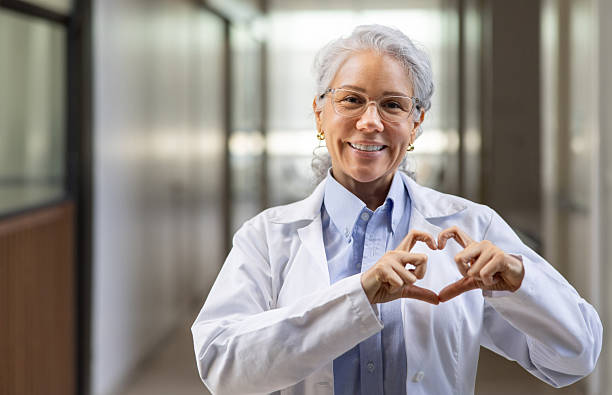 istock Friendly female doctor making a heart shape with her hands and smiling 2220814634