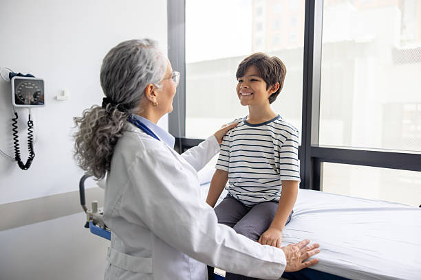 istock Happy boy smiling while paying a visit to the doctor for a check-up 2220816252