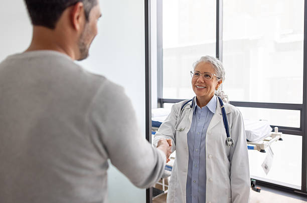 istock Doctor at her office greeting a patient with a handshake and smiling 2220816312