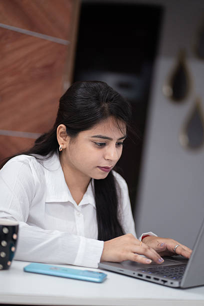 istock Focused Indian Woman Working on Laptop in Office 2220825079