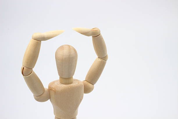 A wooden drawing mannequin creates a perfect OK sign. This image conveys a powerful message despite its simplicity.