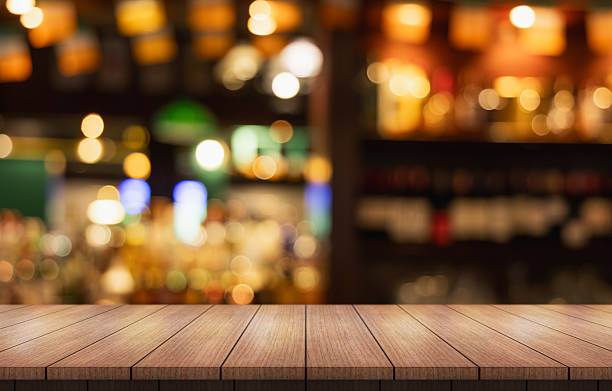 istock Empty wooden table top with lights bokeh on blur restaurant background. 2220829967
