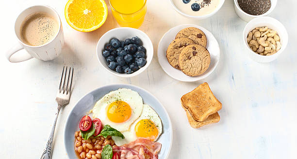 istock Breakfast with fried eggs, bacon, orange juice, yogurt and toasts 2220835339