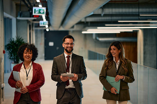 istock Businesspeople walking and talking in office hallway 2220840035