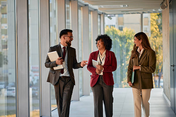 istock Businesspeople walking and talking in modern office hallway 2220840096