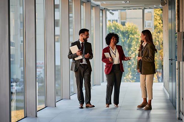 istock Businesspeople walking and talking in modern office hallway 2220840139