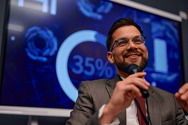 istock Businessman giving a presentation using a microphone and smiling at the audience 2220840307
