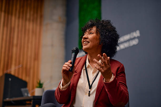 istock Motivational speaker inspiring audience with her speech during a conference 2220840523