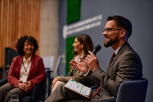 istock Businessman talking on microphone during a panel discussion at a business conference 2220840573