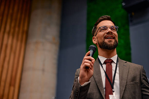 istock Motivational speaker inspiring audience with his speech at corporate event 2220840603