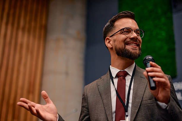 istock Motivational speaker inspiring audience with engaging speech during conference 2220840611