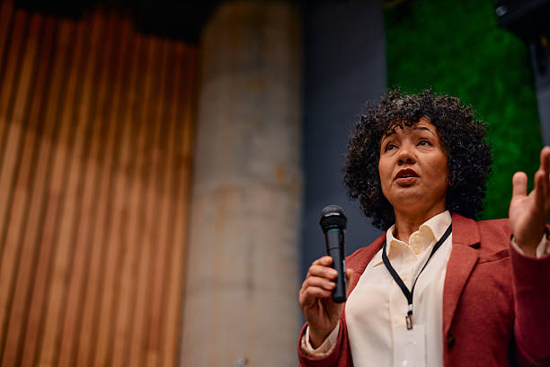 istock Motivational speaker inspiring audience with her speech during a conference 2220840613